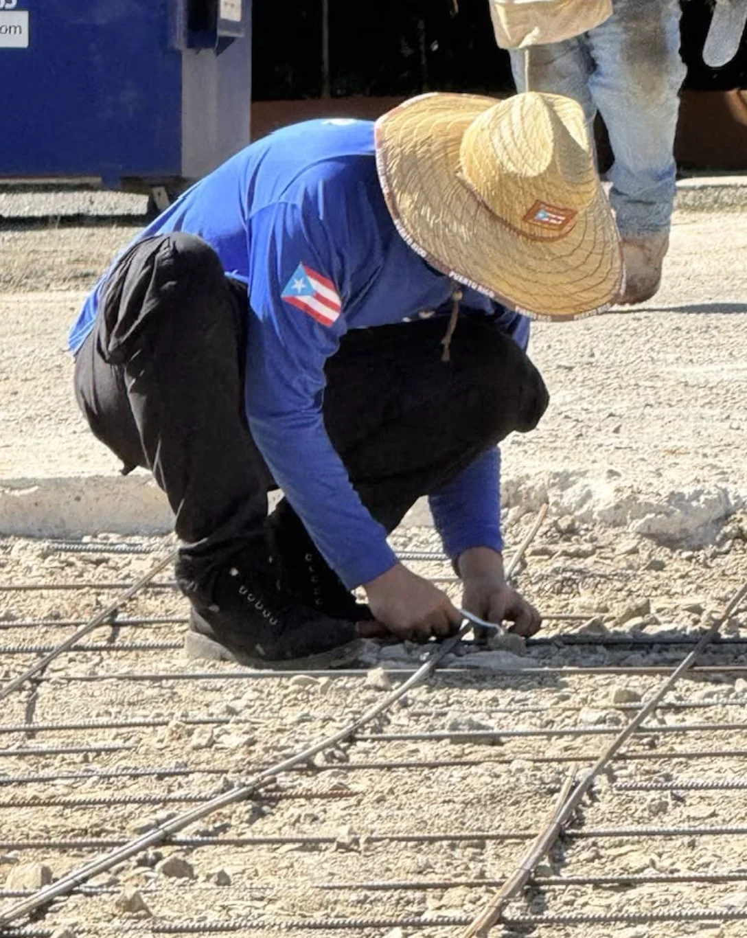 Trabajador de Cuarto Bate 22 LLC amarrando acero en obra